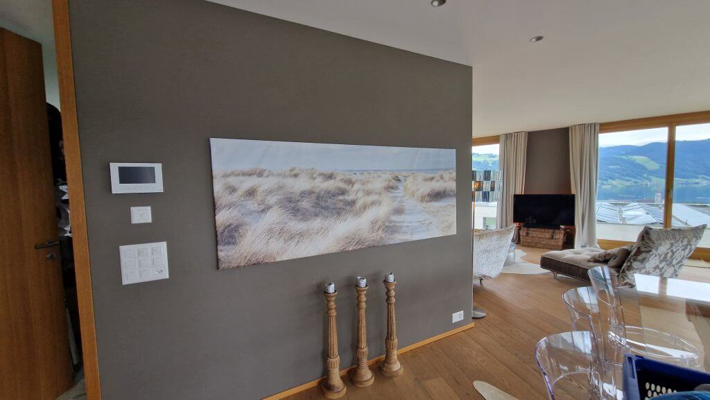 Graue Akzentwand im Wohnbereich mit Bild, Holzboden und Blick in den Raum