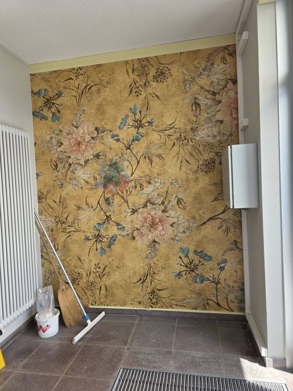 Floral gemusterte Tapete als dekorative Akzentwand in einem Eingangsbereich.