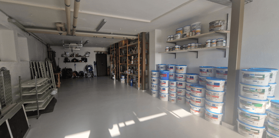 Materiallager von Maler Iten mit Farben, Werkzeugen und sauber organisiertem Arbeitsbereich.