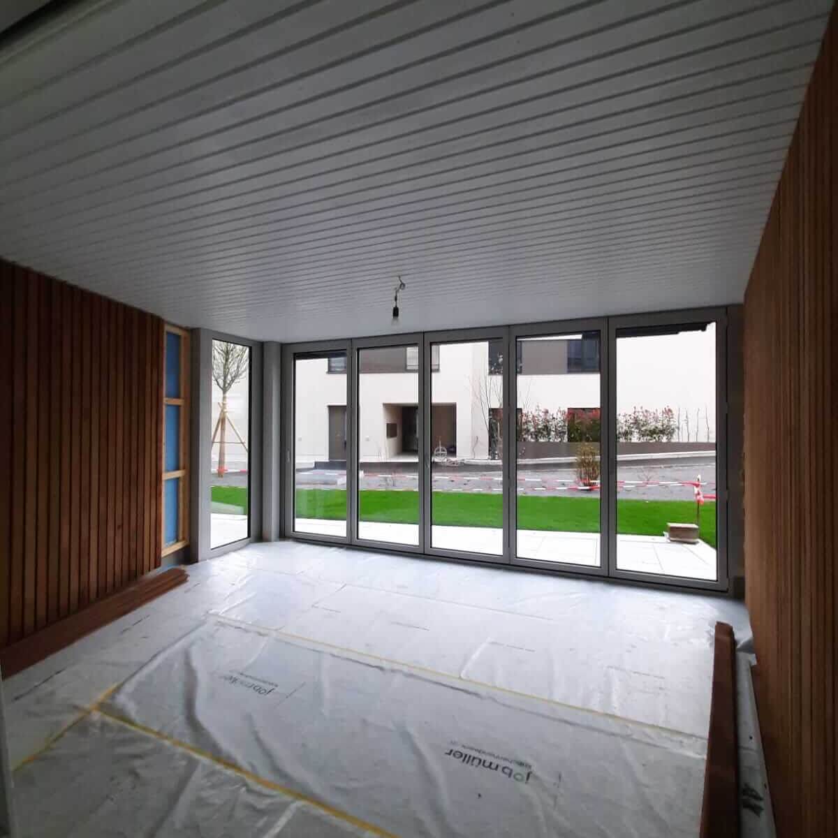 Abgedeckter Raum während Renovationsarbeiten mit geschütztem Boden, Holzverkleidung und frisch bearbeiteter Decke.